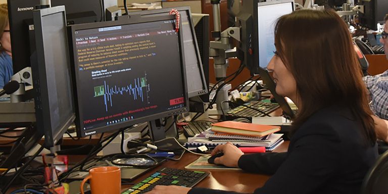 A woman sitting at a desk with a computer. Financial Markets - Inter-Amercian Development Bank - IDB